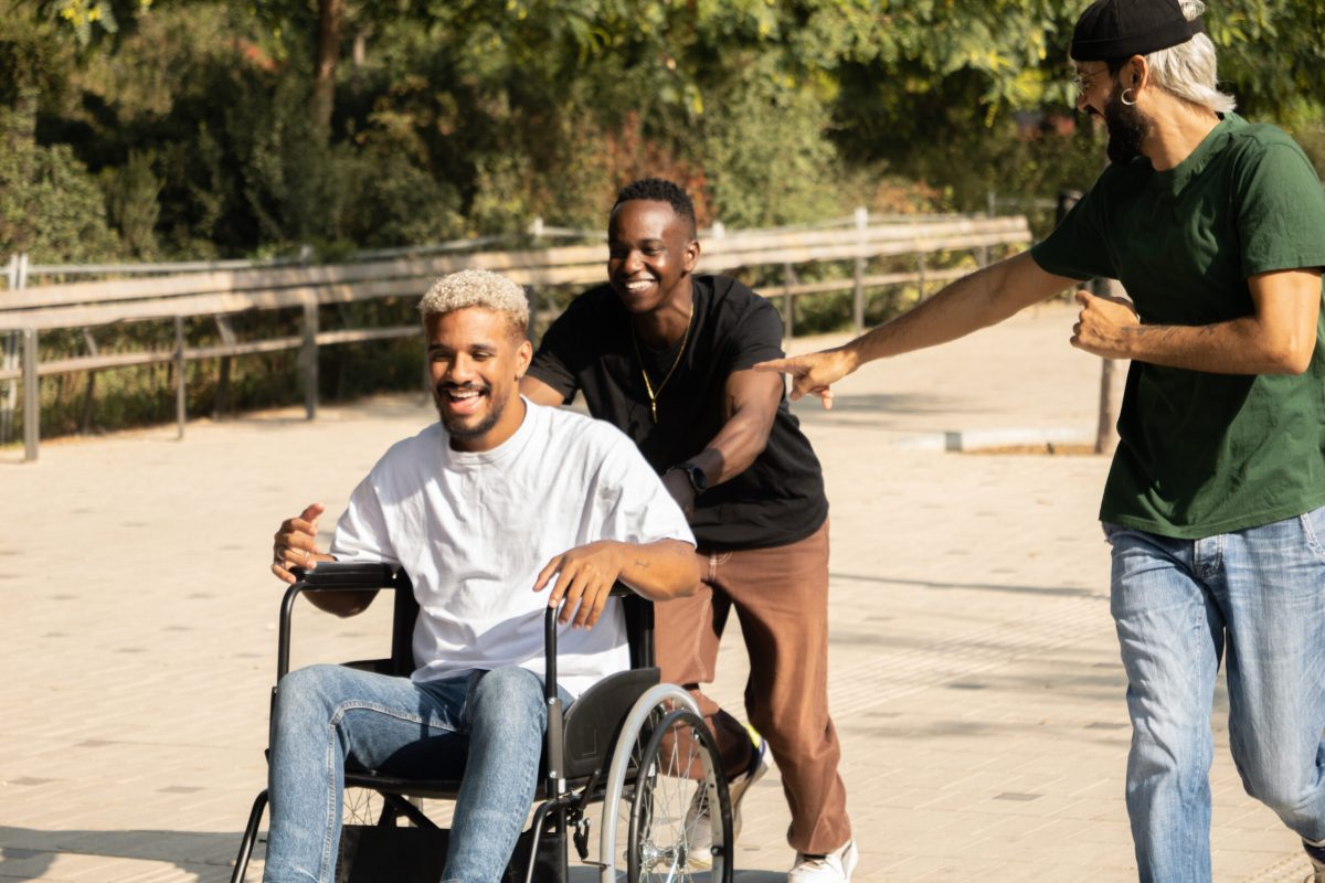 Group of diverse young male friends having fun one of them in a wheelchair having fun in a city. High quality photo
